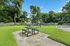 Charming outdoor area with a picnic table and vibrant playground set against a lush green backdrop, perfect for family fun and relaxation.
