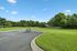 Expansive outdoor space boasting lush green lawns, perfect for leisure and recreation, with convenient bike parking and serene natural surroundings.