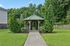 Charming wooden gazebo surrounded by lush greenery, perfect for relaxation and outdoor gatherings.