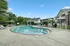 Inviting outdoor pool area with luxurious sun loungers and shaded seating, surrounded by lush greenery and elegant architecture.