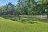 Spacious fenced backyard with lush greenery and tall trees, perfect for relaxation and outdoor activities.