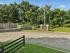 Inviting entrance to Meadows of Lebanon Apartments, showcasing a well-maintained green landscape and welcoming sign surrounded by lush trees.