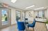 Inviting dining area with elegant glass table, plush blue chairs, and modern decor, ideal for stylish gatherings.