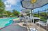 Inviting outdoor pool area with elegant seating and umbrellas, perfect for relaxation under the clear blue sky.