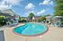 Inviting apartment complex with a sparkling pool, sunny patio, and relaxing loungers for a resort-style living experience.