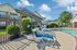 Inviting poolside scene with modern lounge chairs, lush landscaping, and a charming apartment backdrop, perfect for relaxation.