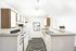 Chic kitchen design featuring sleek white cabinets, modern appliances, and an elegant chevron-patterned rug.