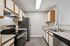 Modern kitchen with sleek appliances, ample cabinetry, and elegant countertops, creating a stylish and functional cooking space.