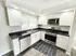 Bright and modern kitchen with sleek stainless steel appliances, elegant white cabinetry, and ample natural light.