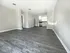 Bright and spacious open-concept living area with sleek hardwood floors and natural light flowing through kitchen windows.