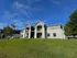 Charming apartment complex with modern architecture set on a lush green landscape under a clear blue sky.