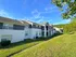 Charming apartment complex with modern exterior, nestled in lush greenery and bright blue skies.