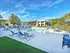 Inviting apartment complex with a sparkling pool surrounded by lush greenery and comfortable loungers, perfect for relaxation.