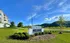Inviting view of The Overlook at Ashland sign amidst a lush green landscape, with modern apartments and scenic hills under a vibrant blue sky.