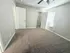 Bright and airy bedroom with soft carpet, modern ceiling fan, and ample closet space, perfect for relaxation.