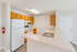 Bright and inviting kitchen with modern appliances, sleek breakfast bar, and warm wooden cabinetry.