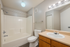 Modern bathroom design featuring elegant vanity with overhead lighting, sleek bathtub, and inviting ambiance.