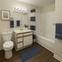 Elegant bathroom with modern fixtures, sleek vanity, and stylish navy accents, offering a fresh and contemporary feel.