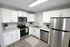 Modern kitchen with sleek stainless steel appliances, white cabinetry, and elegant marble countertops.