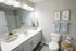 Bright and modern bathroom featuring a sleek vanity, large mirror, and elegant decor with soothing tones.
