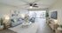 Chic living space featuring a cozy sofa, stylish decor, and a modern open kitchen with stainless steel appliances.