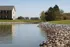 Tranquil waterfront view of a modern home surrounded by lush greenery and serene waterscape.