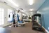 Modern fitness room featuring state-of-the-art exercise equipment, large mirrors, and natural light for an invigorating workout experience.