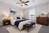 Elegant bedroom with cozy king-sized bed, stylish wooden furniture, and natural light from a large window, perfect for a serene and comfortable living space.
