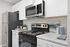 Modern kitchen with sleek stainless steel appliances, elegant white cabinetry, and stylish decor accents.