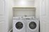 Modern laundry room with sleek Samsung washer and dryer, complemented by soft lighting and ample shelving space.