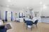 Bright and welcoming office space featuring a modern interior with elegant blue and white furniture, tile flooring, and ample natural light.