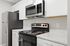 Modern kitchen featuring sleek stainless steel appliances, white cabinetry, and elegant countertops exuding a clean and sophisticated style.