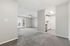 Bright and spacious apartment interior featuring plush carpet, modern kitchen, and natural light streaming through large windows.