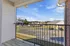 Inviting balcony view overlooking a quiet residential neighborhood, perfect for relaxing and enjoying the blue sky.