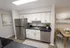 Bright, modern kitchen with sleek stainless-steel appliances, elegant white cabinetry, and a cozy dining area, perfect for contemporary living.