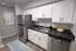 Chic modern kitchen with sleek stainless steel appliances, stylish white cabinetry, and elegant black countertops, perfect for any home chef.