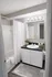 Elegant bathroom with modern fixtures, featuring a sleek vanity, large mirror, and shower-tub combo, accented by cozy decor.