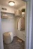 Modern walk-in closet featuring elegant wicker baskets, plush carpet, and ample hanging space for clothing.