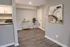 Modern apartment interior showcasing a stylish open corner with elegant flooring, a chic artwork, and a cozy bar cart setup.