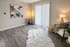 Chic living room with modern decor, featuring a cozy fur rug, abstract wall art, and elegant lighting by a large window.