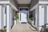 Inviting apartment entrance highlighted by modern white pillars and lush greenery in elegant planters.