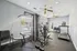Bright and airy fitness room equipped with modern gym equipment, including a treadmill and multifunctional strength machine, perfect for a convenient workout.