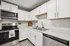 Modern kitchen with sleek stainless steel appliances, white cabinetry, and spacious countertops offering a chic and functional design.