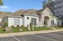 Charming apartment complex clubhouse with elegant architecture and well-maintained landscaping, offering a welcoming atmosphere.