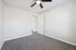 Bright and spacious bedroom with plush carpeting, ceiling fan, and neutral walls, offering a fresh canvas for personalized decor.