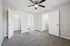 Bright and spacious bedroom with plush carpeting, ceiling fan, and convenient access to a walk-in closet and en-suite bathroom.