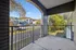 Charming apartment balcony with scenic views of lush greenery and modern buildings, perfect for relaxing outdoors.
