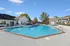 Inviting outdoor pool area with lounge chairs and umbrellas, perfect for relaxation and leisure, surrounded by charming apartment buildings.