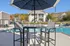 Luxurious apartment community poolside setting with modern seating and lush green surroundings on a sunny day.
