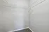 Expansive walk-in closet with white shelving and plush carpet, perfect for ample storage and organization.